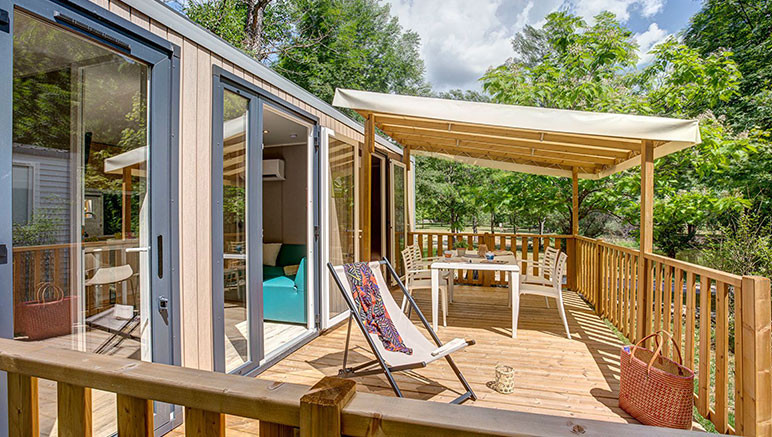 Vente privée Camping 5* Les Péneyrals – Grande terrasse semi couverte avec salon de jardin et bains de soleil