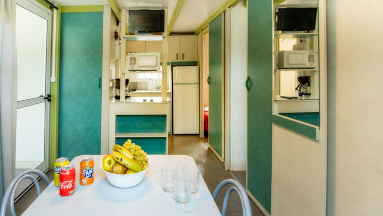 Vente privée Camping 4* Vilanova Park – Salon ouvert sur la cuisine du chalet pour 5 personnes